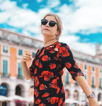 a woman wearing a black and red floral dress and sunglasses