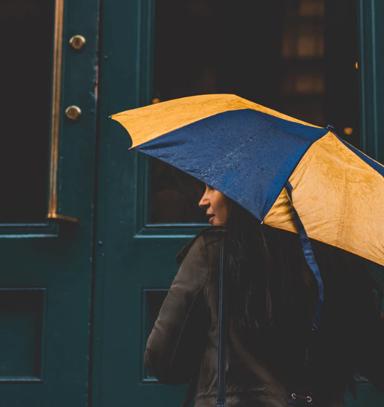 woman under a black and orange automatic umbrella