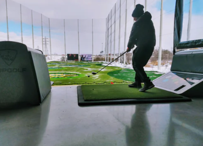 A man playing golf indoors on a simulator