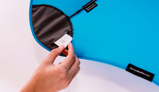 a Tile being inserted into a blue Blunt umbrella