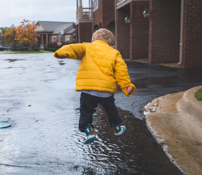 a child jumping in a puddle