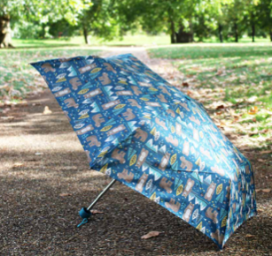 a Totes compact umbrella on grass