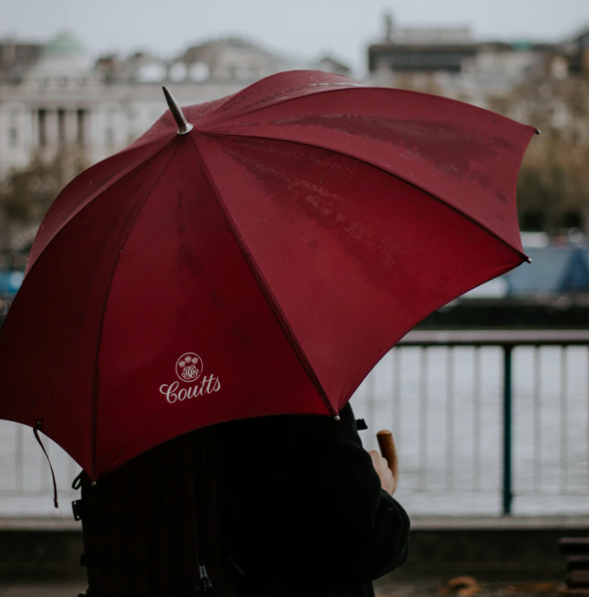person-holding-red-branded umbrella